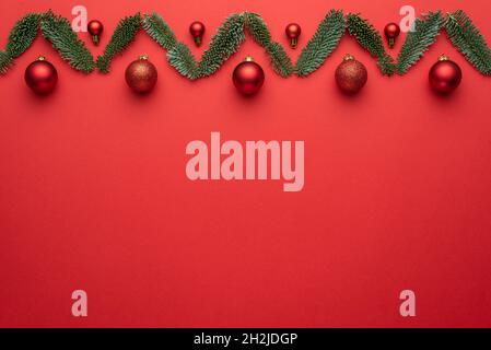 Carte de vœux avec décoration de Noël sur fond rouge avec espace pour le texte.Plan à plat, vue de dessus et espace de copie pour le texte Banque D'Images