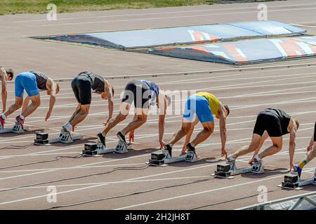 des athlètes de groupe dans les blocs de départ à la compétition d'athlétisme Banque D'Images