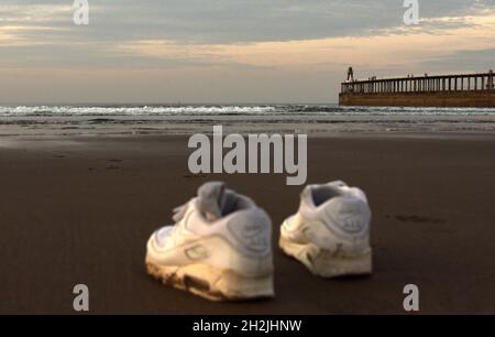 Une paire de chaussures sur une plage au crépuscule à Whitby Banque D'Images