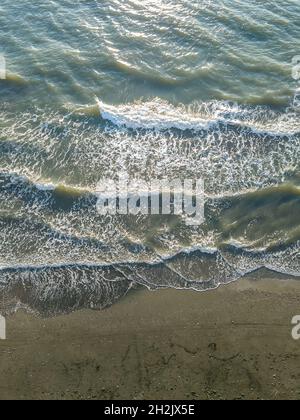 Vue de dessus du drone à la plage de sable de la mer avec de grandes vagues par une journée ensoleillée.Photo verticale Banque D'Images