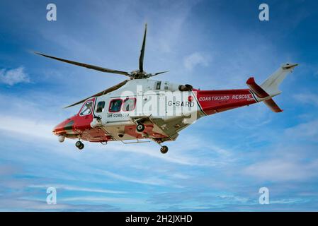 Hélicoptère de sauvetage HM Coastguard volant dans un ciel bleu, gros plan. Banque D'Images