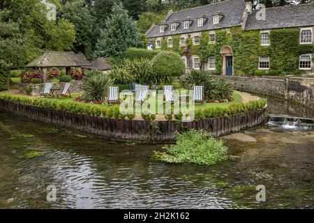 Le joli jardin paysagé de l'ivy Covered Swan Hotel dans le village pittoresque de Bibury, dans les Cotswolds de Gloucestershire, en Angleterre. Banque D'Images