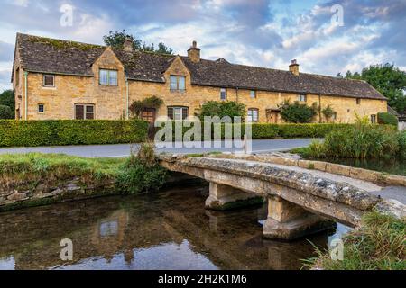 Passerelle en pierre enjambant le River Eye dans le pittoresque village de Lower Slaughter, dans les Cotswolds, à Gloucestershire, en Angleterre. Banque D'Images