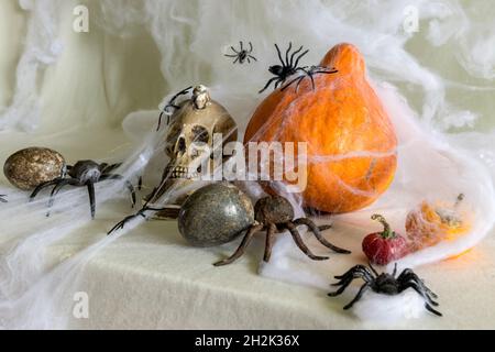 décoration et concept de vacances, thème d'halloween, citrouille d'orange et crâne enveloppés dans toile d'araignée, attaque d'araignée, fête d'halloween Banque D'Images