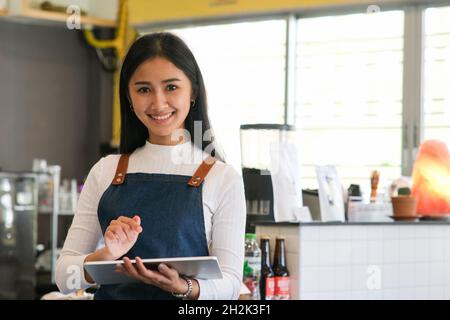Cheerful mature waitress waiting for clients at coffee shop. Successful small business owner. Banque D'Images