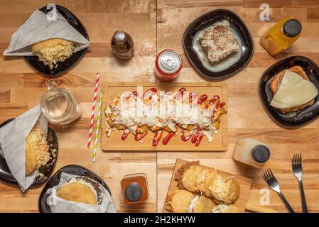 Vue de dessus des plats de la cuisine vénézuélienne.Arepas varié, queen pepiada, dominos, jus de fruits tropicaux, gâteau de sangsues,patacón au fromage et au cor Banque D'Images