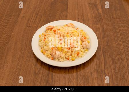 Délicieux riz aux crevettes, morceaux de maïs doux et de tortilla et carottes cuites par un chef chinois Banque D'Images