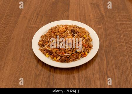 Riz frit avec sauce soja, pousses de haricots, crevettes frites, maïs doux, morceaux de poulet et carottes cuites selon une recette de restaurant chinois Banque D'Images