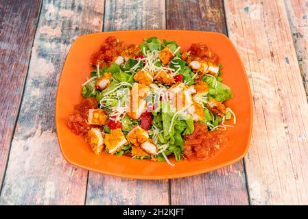 Salade de poivrons avec laitue, fromage râpé et filets de poulet panés en tranches Banque D'Images