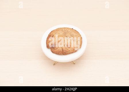 Biscuit au chocolat blanc caramélisé fraîchement cuit sur une table en bois clair Banque D'Images