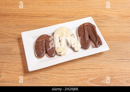 Petits palmiers avec revêtement chocolat blanc et foncé sur un plateau blanc Banque D'Images