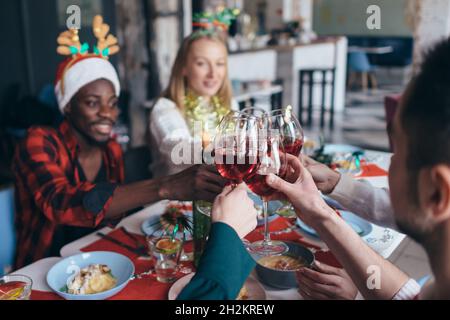 Groupe de personnes à une table festive cloque verres. Banque D'Images