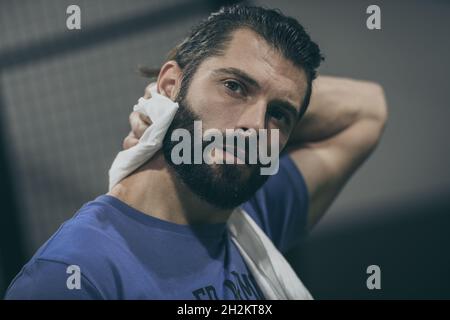 Beau homme essuye la sueur après une séance d'entraînement.Jeune garçon sportif à la fin du match.Un athlète en sueur avec une serviette à la main prête à prendre le spectacle Banque D'Images