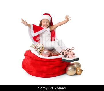 Jolie petite fille en costume du Père Noël et avec un sac plein de belles décorations de Noël sur fond blanc Banque D'Images