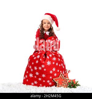 Jolie petite fille en costume de Père Noël et avec sac sur fond blanc Banque D'Images