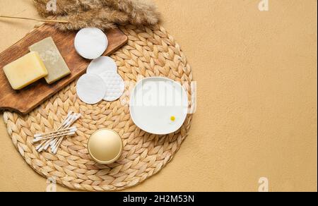 Tapis en osier avec tampons de coton, bourgeons et savon sur fond de couleur Banque D'Images