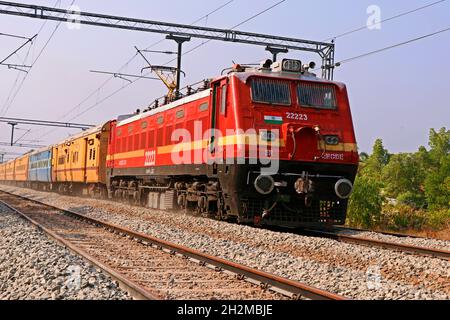 Kochi, Kerala, Inde -25 mars 2021 un train de passage se déplaçant avec un support électrique à travers la voie dans le chemin de fer indien Banque D'Images