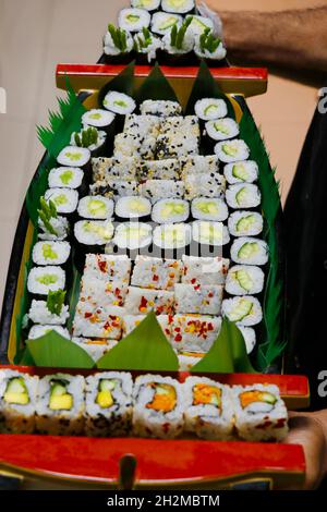 sélection multiple de petits pains à sushis japonais dans un bateau, incluant saumon, thon, crabe, crevettes, etc Banque D'Images