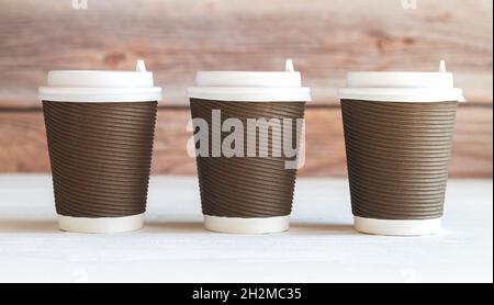 Trois tasses à café en papier à emporter diaposable ondulé avec bouchons en gros plan Banque D'Images