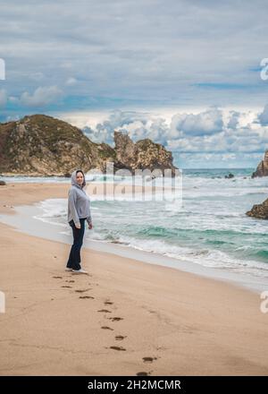 femme d'âge moyen marchant le long de la ligne de l'océan en automne, hiver, vie active. marche le long de la mer par temps frais. côte de californie Banque D'Images