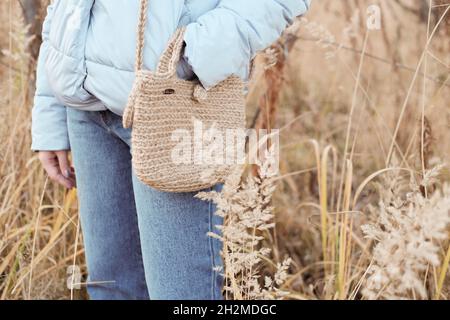 Sac à provisions en jute naturel fait main, style scandinave, tons beige, accessoires de mode durables.Un style de vie sans gaspillage.Femme debout dans un champ avec sac de jute de bricolage Banque D'Images