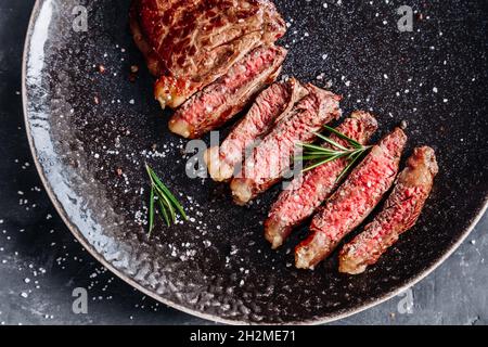 New York striploin steak moyen rare avec vue sur le dessus du romarin Banque D'Images