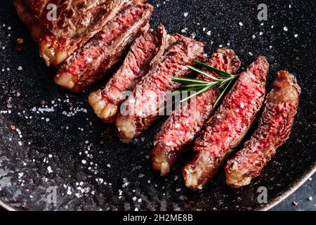 New York striploin steak moyen rare avec vue sur le dessus du romarin Banque D'Images