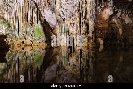 Ancienne grotte du nord de la Sardaigne avec lac intérieur, réflexions, stalactites et stalagmites Banque D'Images