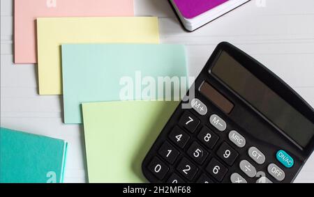 Sur un fond blanc calculatrice, autocollants multicolores et bloc-notes Banque D'Images