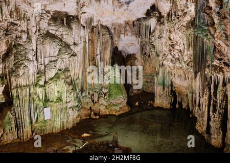 Ancienne grotte du nord de la Sardaigne avec lac intérieur, réflexions, stalactites et stalagmites Banque D'Images