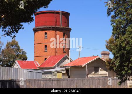 Ancienne tour d'eau de chemin de fer en brique rouge et chalets en panneaux d'intempéries avec rooves en fer ondulé rouge à Warracknabeal, Wimmera Mallee, Victoria, Australie Banque D'Images