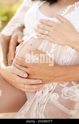 Couple enceinte heureux sur fond naturel gros plan Banque D'Images