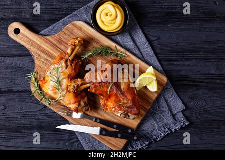tiges de porc grillées croustillantes sur une planche de bois avec romarin, quartiers de citron et moutarde, vue horizontale depuis le dessus, plat, espace libre Banque D'Images