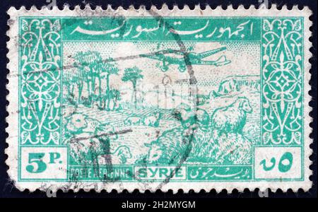 SYRIE - VERS 1947: Un timbre imprimé en Syrie montre l'avion et la Flock de mouton, vers 1947 Banque D'Images