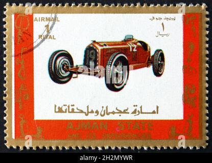 AJMAN - VERS 1973 : un timbre imprimé à Ajman montre une vieille voiture de course, vers 1973 Banque D'Images