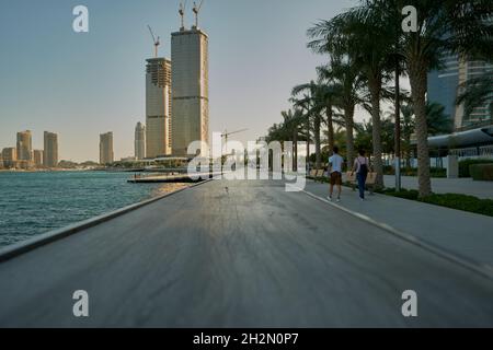 Lusail Corniche à la marina de Lusail City, Qatar, vue sur la lumière du jour, montrant les personnes marchant sur la promenade et les gratte-ciel en arrière-plan Banque D'Images