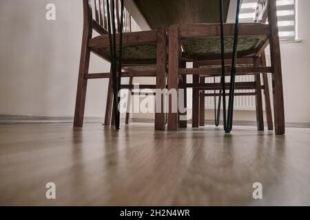 Intérieur de maison avec table en bois et en métal sur le plancher en bois devant la fenêtre soleil venant des fenêtres. Banque D'Images