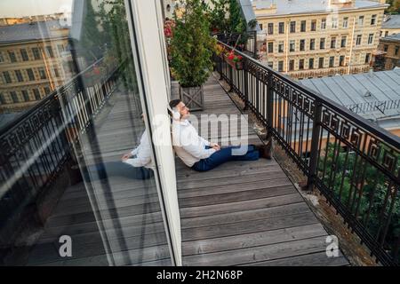 Homme d'affaires se détendant dans le balcon de bureau Banque D'Images