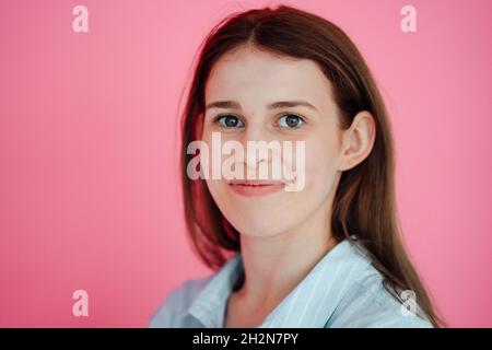 Jeune femme avec de longs cheveux sur fond rose Banque D'Images