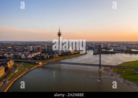 Allemagne, Rhénanie-du-Nord-Westphalie, Düsseldorf, vue aérienne du pont Rhinekniebrucke au crépuscule avec tour du Rhin en arrière-plan Banque D'Images