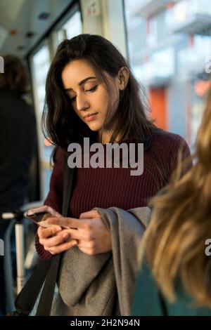 Femme utilisant un smartphone en tram Banque D'Images