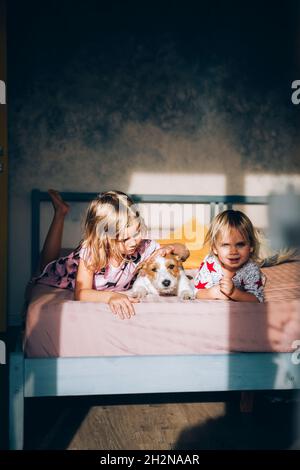 Jack Russell Terrier avec des filles au lit à la maison Banque D'Images