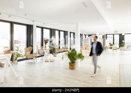 Homme d'affaires marchant dans le bureau Banque D'Images