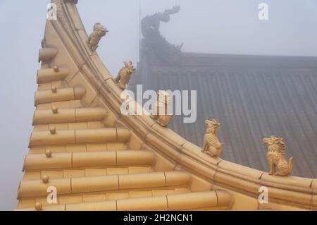 Petites créatures mythiques au sommet de la salle d'or bouddhiste lors d'une soirée brumeuse sur l'éméishan dans la province du sichuan en chine. Banque D'Images