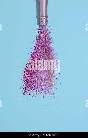 Bouteille de champagne avec des confettis sur fond de papier bleu.Célébration de la Saint-Valentin Banque D'Images