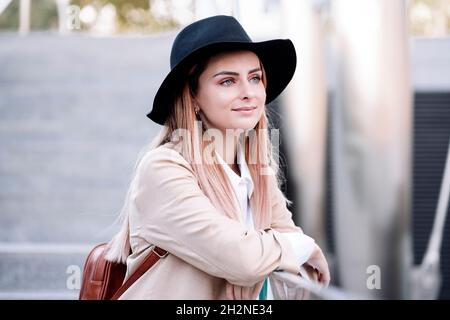 Jeune femme attentionnés portant un chapeau incliné sur la main courante Banque D'Images