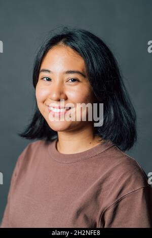 Smiling young woman in studio Banque D'Images