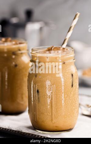Deux Mason Jars remplis de café glacé avec du lait ou de la crème et des pailles Banque D'Images