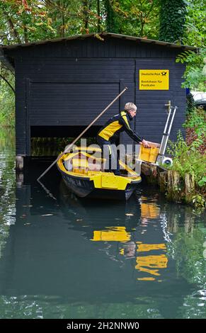 14 octobre 2021, Brandebourg, Lübbenau: À la Deutsche Post Boathouse dans le Spreewald, Andrea Bunar, Deutsche Post livreaute, charge la barge postale jaune.L'automne est ici et avec elle la fin de la saison de livraison de barges dans le Spreewald.Le 15.10.21, la postfemme Andrea Bunar embarque pour la dernière fois cette année à bord de la barge jaune.Jusqu'au printemps, l'homme de 50 ans devra se rapprocher autant que possible des maisons et ensuite couvrir de plus longues distances à pied.A partir de maintenant, Deutsche Post utilisera le transporteur électrique Street Scooter lors de cette excursion.Cela signifie que les livraisons dans le SP Banque D'Images