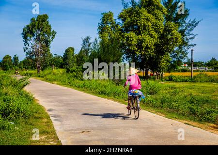 Faire du vélo autour de Cam Kim Island avec chapeau conique. Banque D'Images